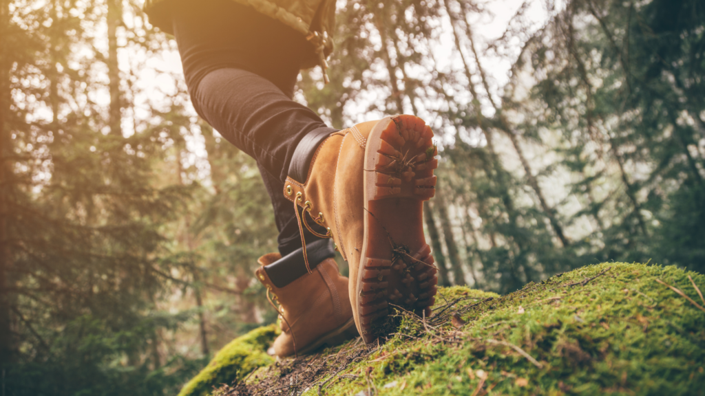 feet in boots hiking through woods